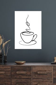 a black and white drawing of a cup of coffee on a wall above a dresser