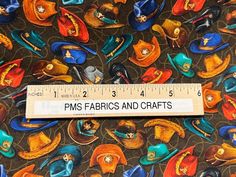 a ruler is on top of a fabric with colorful hats and other items in it