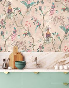 the wallpaper in this kitchen is very colorful and has birds on branches with flowers