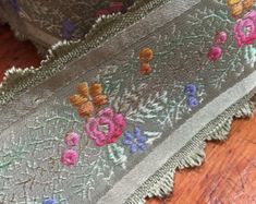 an embroidered piece of cloth with flowers on it