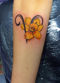 a yellow flower tattoo on the arm