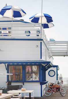 a white and blue building with umbrellas over it