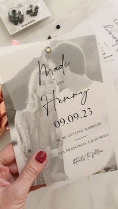 a person holding up a wedding card