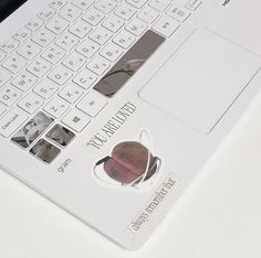 an open laptop computer sitting on top of a white desk next to a mouse and keyboard