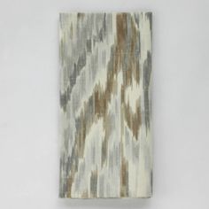 a piece of cloth with an abstract design on the front and back, hanging from a wall