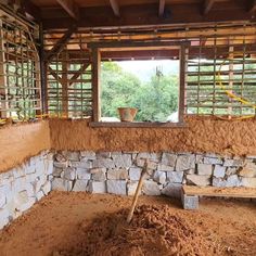 the inside of a building that is being built with wood chips and sand on the ground