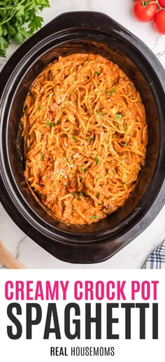 creamy crock pot spaghetti in a slow cooker with tomatoes and parsley on the side