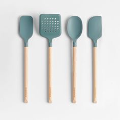 three green spatulas and two wooden spoons