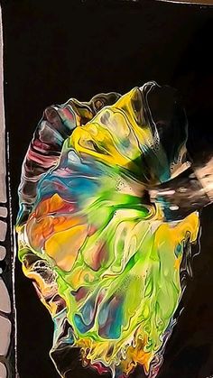 an abstract painting of a flower on a black background