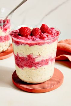 two desserts with raspberries and cream in them