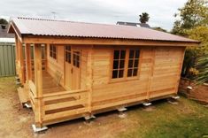 a small wooden cabin with a metal roof