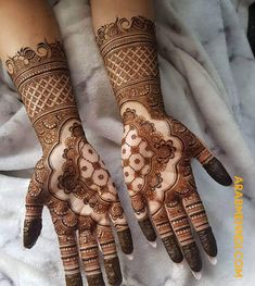 two hands with henna tattoos on them, one is showing the intricate design and the other has an intricate pattern