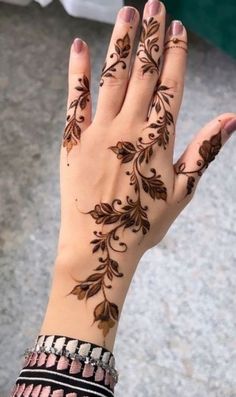 a woman's hand with henna tattoos on it