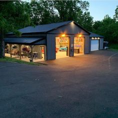 a garage with two cars parked in it and lights on the side of the building