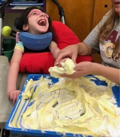 a young child is laughing while being held by an adult in a walker's chair