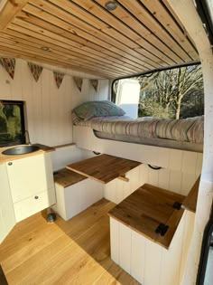 the inside of a camper with wood flooring and built in bunk bed area