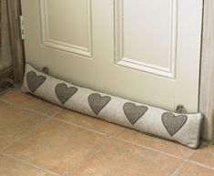 a dog is sitting in front of a door with hearts on it's pillow