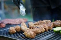 someone is grilling meat on the grill with cucumbers and pickle slices