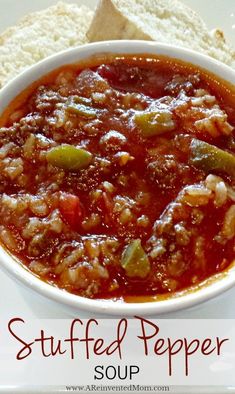 a bowl of stuffed pepper soup next to a piece of bread on a white plate