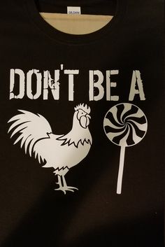 a black t - shirt with a white rooster holding a lollipop on it