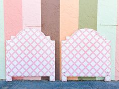 a pink headboard against a multicolored wall in front of a building with two doors