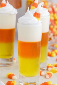 two glasses filled with candy corn and whipped cream