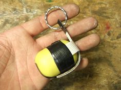 a hand holding a small yellow and black object