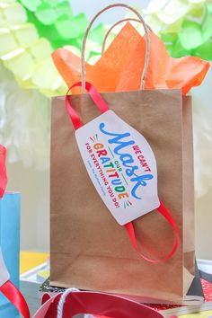 a brown paper bag sitting on top of a table next to other colorful items and decorations