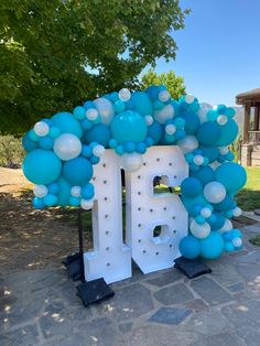 the balloon arch is decorated with blue and white balloons