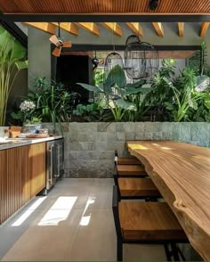 an outdoor dining area with wooden tables and hanging birdcages on the ceiling, surrounded by greenery