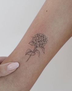 a woman's arm with a flower tattoo on the left side of her arm