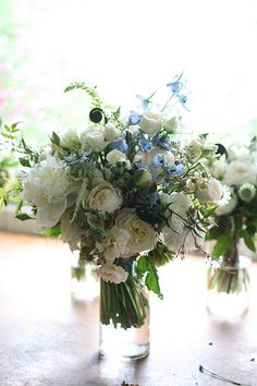 three vases filled with white and blue flowers