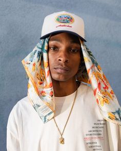 a young man wearing a hat and scarf over his head with words written on it