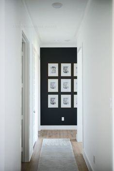 an empty hallway with black and white pictures on the wall