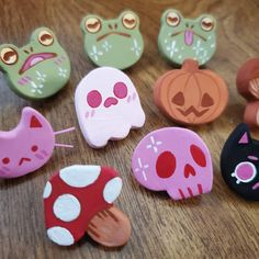 there are many different types of buttons on this wooden table, including cats and skulls