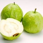 two green apples with one cut in half and the other whole, on a white background