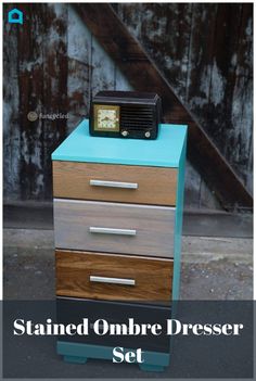 an old radio sitting on top of a chest of drawers in front of a wooden wall