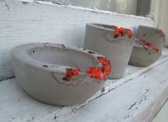 three cement pots sitting on top of a window sill