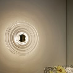 a bathroom sink with a circular light above it