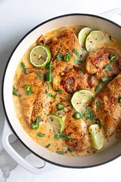 a pan filled with chicken and limes on top of a table