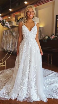 a woman in a white wedding dress standing on a wooden floor