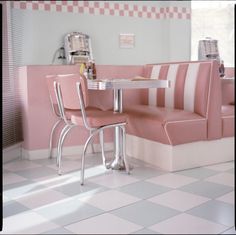 a pink and white restaurant with checkered flooring on the walls, tables and chairs