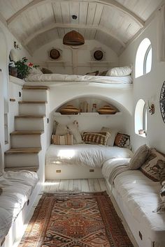 a living room filled with lots of white furniture and pillows on top of a rug