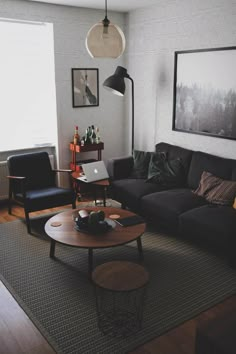 a living room filled with furniture and a laptop computer on top of a wooden table