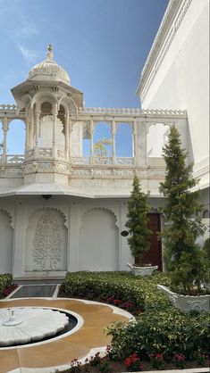 an ornate white building with a fountain in the middle