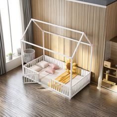 a white dollhouse bed in a wooden floored room