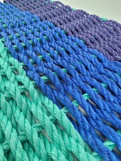 there are many different colors of rope on the table together and one is blue, green, purple, and white