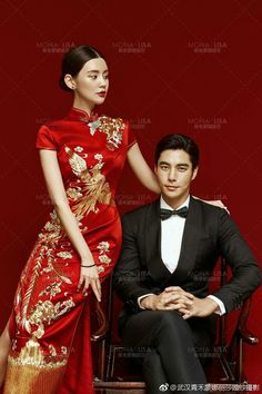 a man in a tuxedo sitting next to a woman in a red dress