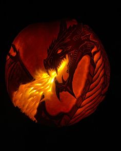 a carved pumpkin with a dragon on it's face and flames coming out of its mouth