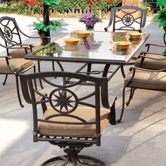 an outdoor dining table with chairs around it